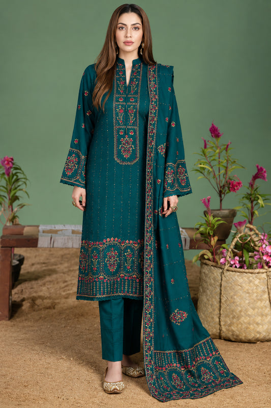 A woman modeling a traditional three-piece salwar kameez suit in deep teal green multicolor embroidery in red, gold, and beige on the kurta, pants, and matching dupatta